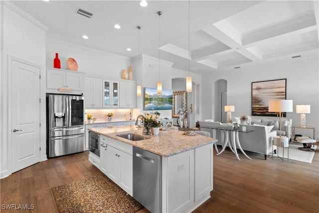 kitchen featuring dark wood-type flooring, appliances with stainless steel finishes, arched walkways, and a sink