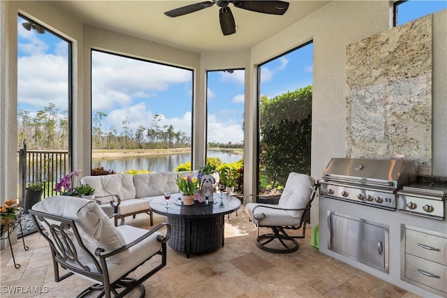 sunroom / solarium with a ceiling fan and a water view