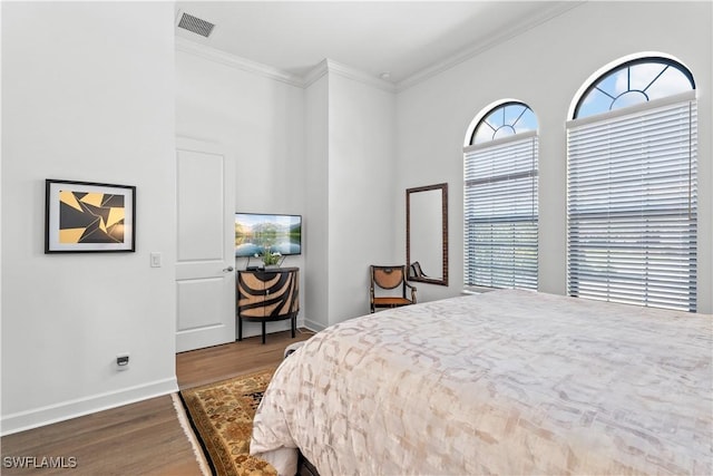 bedroom featuring ornamental molding, visible vents, baseboards, and dark wood-style floors