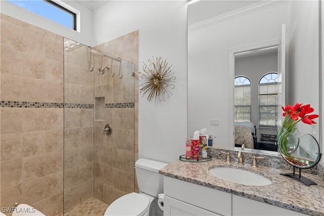 ensuite bathroom with a healthy amount of sunlight, toilet, a tile shower, and connected bathroom