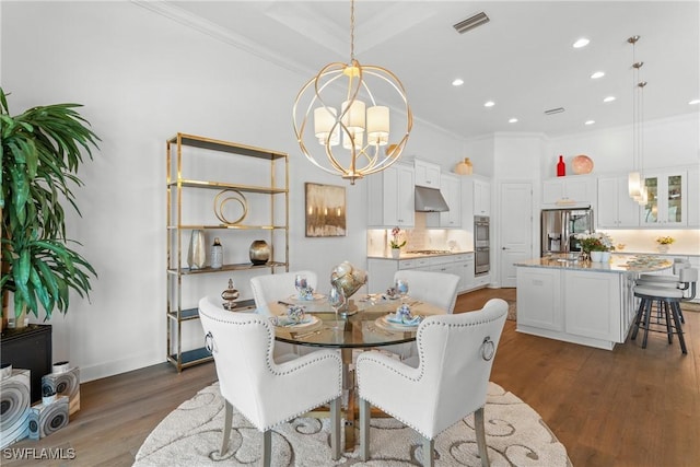 dining space with a chandelier, dark wood-style flooring, visible vents, and ornamental molding