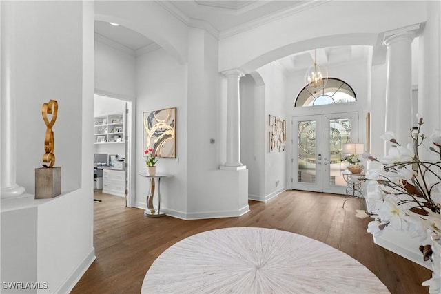 entrance foyer with french doors, crown molding, decorative columns, wood finished floors, and baseboards