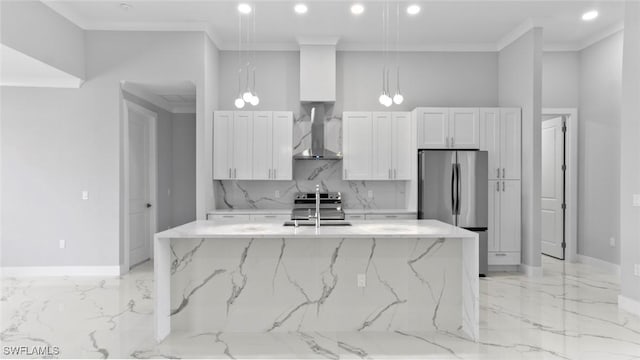 kitchen with marble finish floor, appliances with stainless steel finishes, white cabinetry, and wall chimney range hood