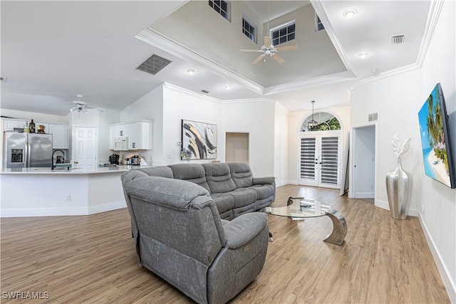 living room featuring ornamental molding, light hardwood / wood-style floors, and ceiling fan