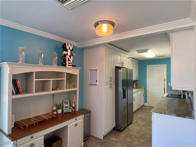 kitchen with dark stone countertops, white cabinetry, stainless steel refrigerator with ice dispenser, and crown molding