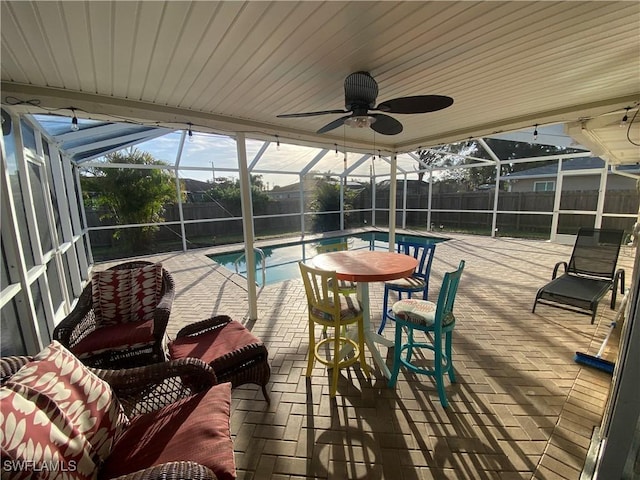 view of patio featuring a ceiling fan, glass enclosure, a fenced backyard, and a fenced in pool