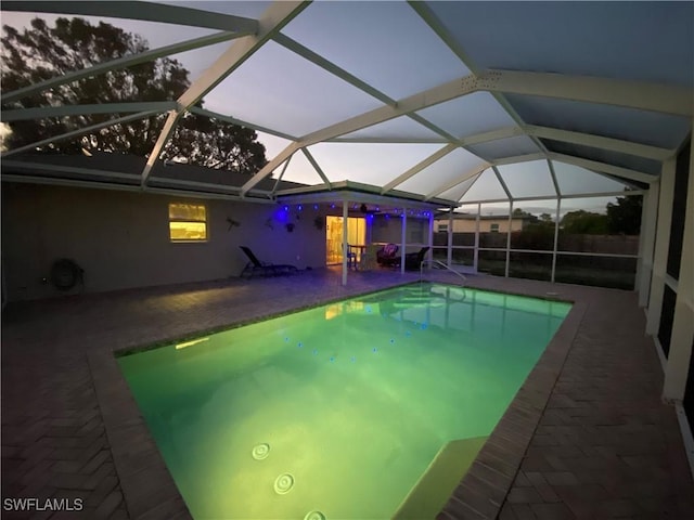 outdoor pool featuring glass enclosure and a patio area