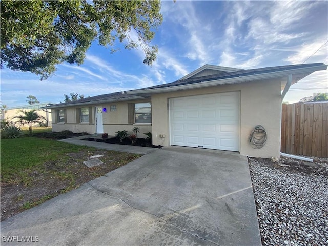 ranch-style house with a garage, concrete driveway, fence, and stucco siding