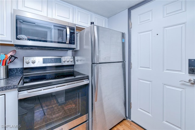 kitchen featuring stainless steel appliances, light hardwood / wood-style floors, and white cabinets