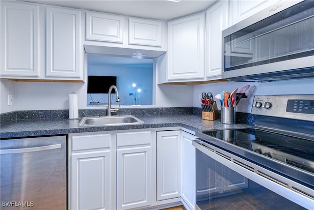 kitchen featuring appliances with stainless steel finishes, sink, and white cabinets