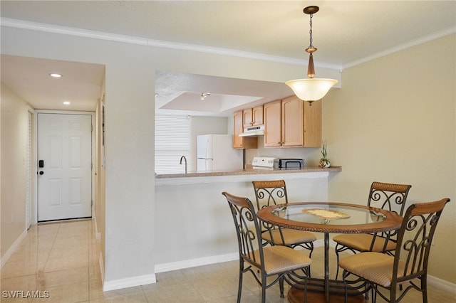 tiled dining room with ornamental molding and sink