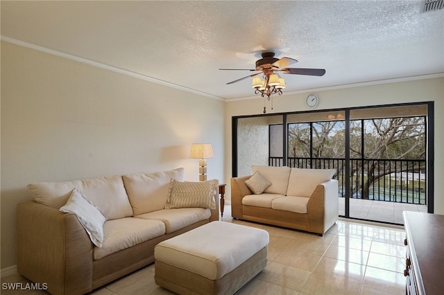 tiled living room featuring ceiling fan, ornamental molding, and a textured ceiling