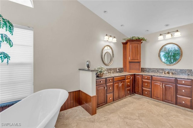 bathroom with vanity, a tub to relax in, tile patterned flooring, and vaulted ceiling