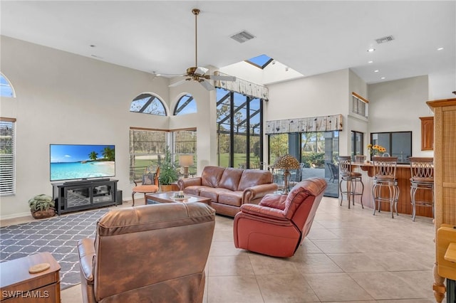 tiled living room with a towering ceiling, a wealth of natural light, and ceiling fan