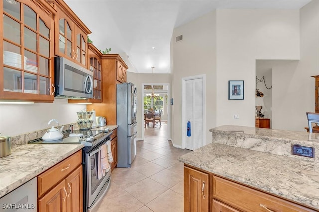 kitchen featuring light stone counters, light tile patterned floors, and appliances with stainless steel finishes