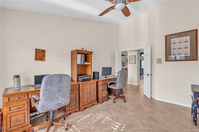 home office featuring a towering ceiling and ceiling fan