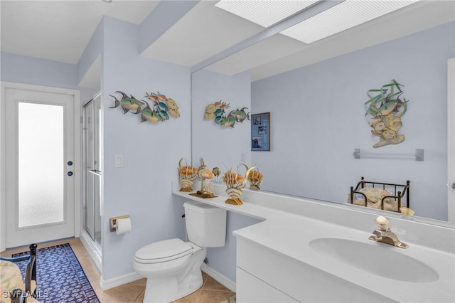 bathroom featuring tile patterned flooring, vanity, toilet, and walk in shower