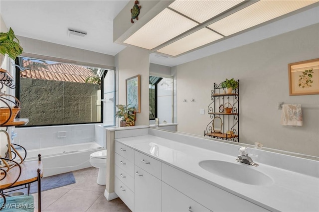 bathroom featuring tile patterned flooring, vanity, a washtub, and toilet