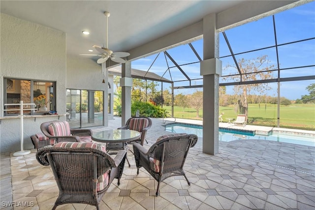 view of patio featuring exterior bar, ceiling fan, and a lanai