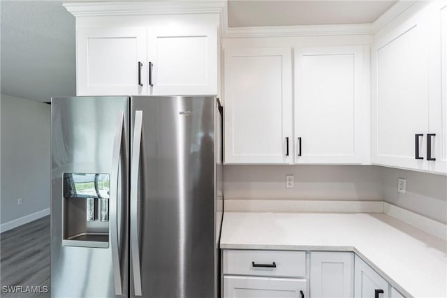 kitchen with hardwood / wood-style flooring, white cabinets, and stainless steel fridge with ice dispenser