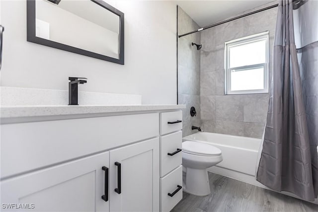 full bathroom featuring wood-type flooring, toilet, vanity, and shower / bath combo with shower curtain