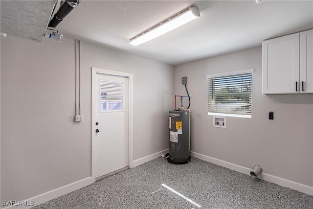 laundry room with electric water heater and a textured ceiling