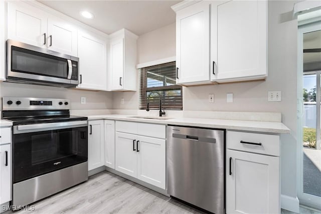 kitchen with white cabinetry, appliances with stainless steel finishes, sink, and plenty of natural light