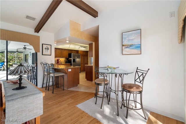 interior space with lofted ceiling with beams, ceiling fan, and light hardwood / wood-style flooring