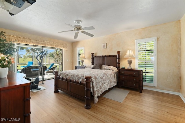 bedroom featuring multiple windows, access to exterior, and light hardwood / wood-style floors