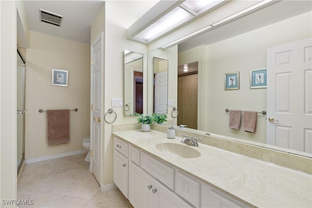 bathroom featuring tile patterned flooring, vanity, and toilet