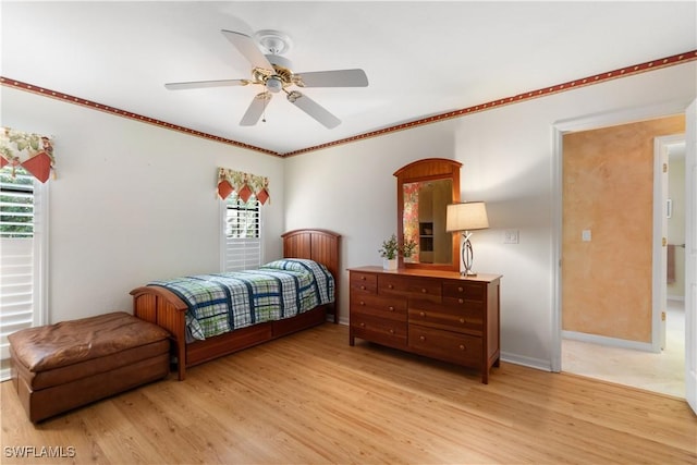 bedroom featuring crown molding, multiple windows, and light hardwood / wood-style flooring