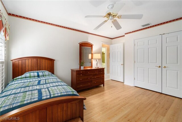 bedroom featuring crown molding, a closet, ceiling fan, and light hardwood / wood-style flooring