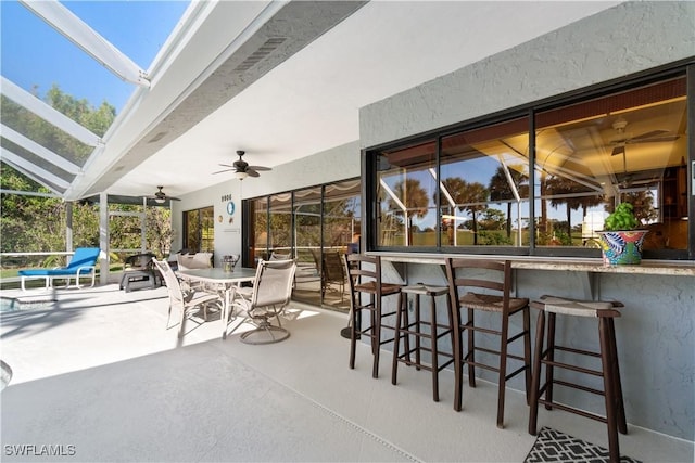 view of patio / terrace featuring ceiling fan and exterior bar