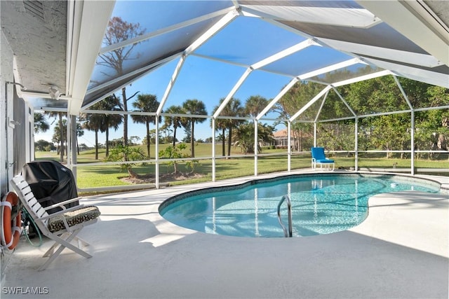 view of pool with a lawn, glass enclosure, and a patio area