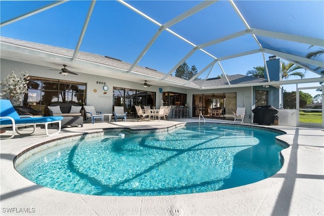 view of pool with a patio, ceiling fan, and glass enclosure