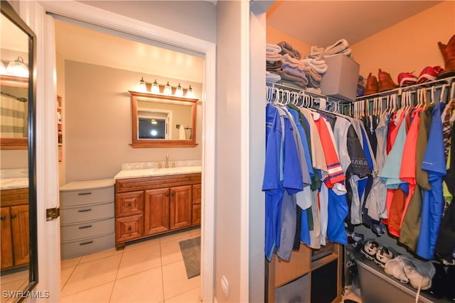 walk in closet featuring light tile patterned flooring and sink