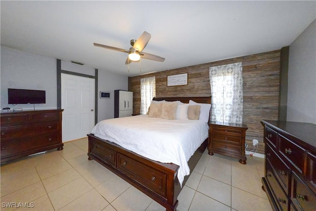 tiled bedroom featuring wooden walls and ceiling fan