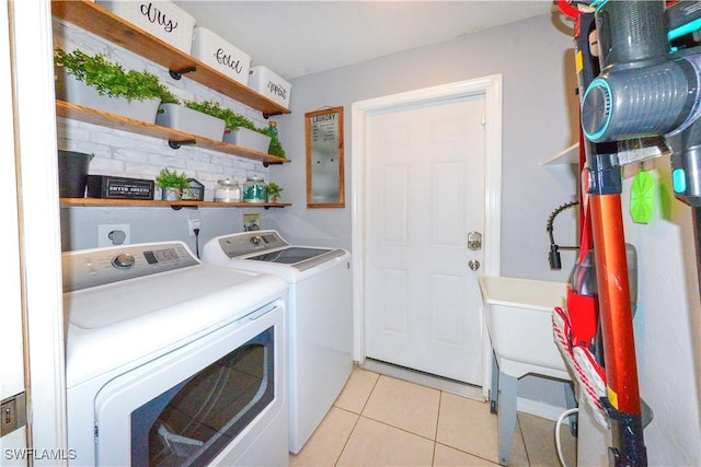 laundry room with washer and dryer and light tile patterned floors