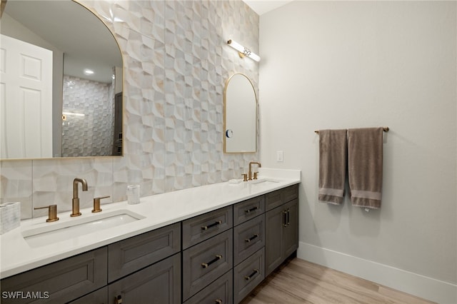 bathroom with vanity, hardwood / wood-style floors, a shower, and backsplash