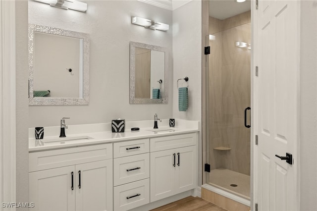 bathroom featuring an enclosed shower, vanity, and wood-type flooring