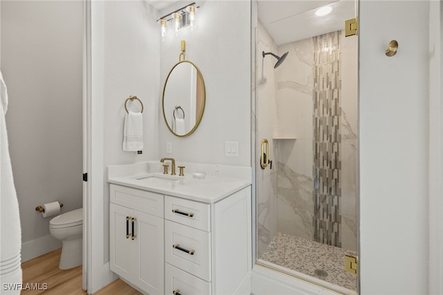 bathroom featuring vanity, toilet, an enclosed shower, and hardwood / wood-style floors