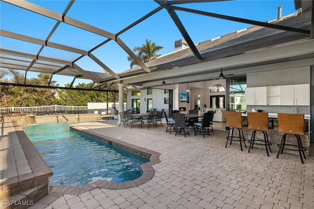 view of swimming pool with a bar, a lanai, and a patio area