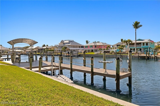 view of dock with a yard and a water view