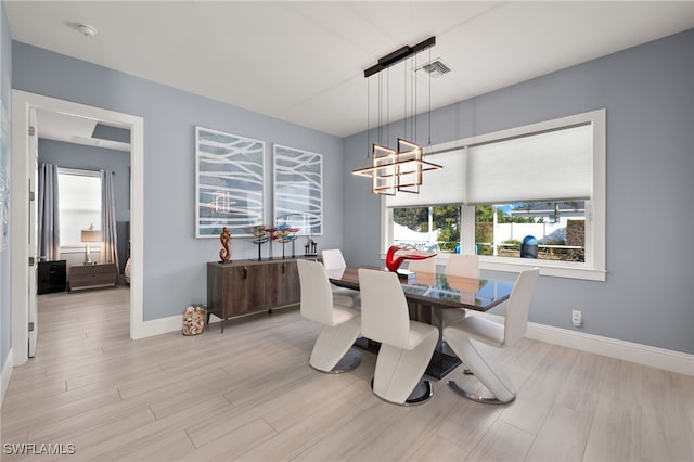 dining room with light hardwood / wood-style flooring and a chandelier