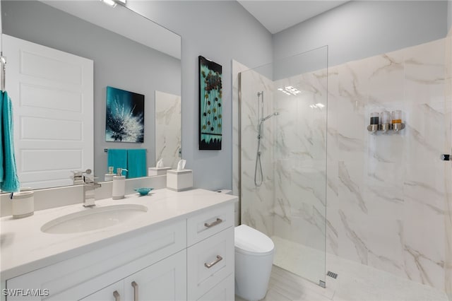 bathroom with vanity, toilet, and tiled shower