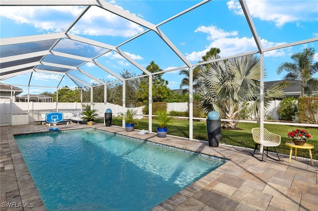 view of pool with a yard, a patio area, and glass enclosure