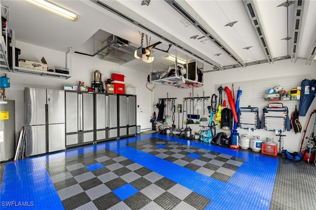 garage featuring water heater, a garage door opener, and stainless steel refrigerator