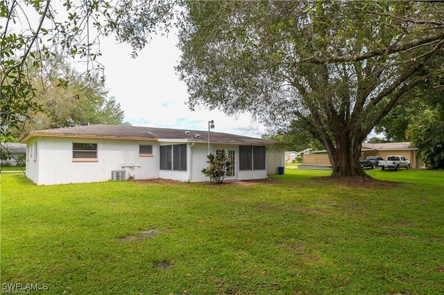 rear view of property featuring central AC unit and a yard