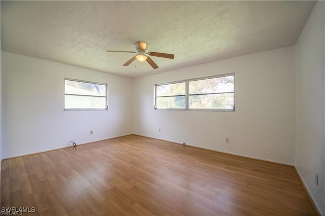 spare room with hardwood / wood-style flooring, ceiling fan, and a textured ceiling