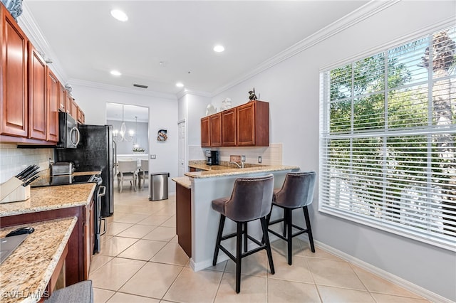 kitchen with crown molding, stainless steel electric range, a breakfast bar area, and light tile patterned floors